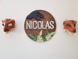 Best-selling 23" round sign featuring a captivating Jurassic theme. Silhouette dinosaur design customizable in any colors, accompanied by Jurassic leaves in the background for a vibrant and personalized addition to your child's room."